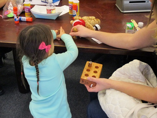 A mother and her blind child doing Braille